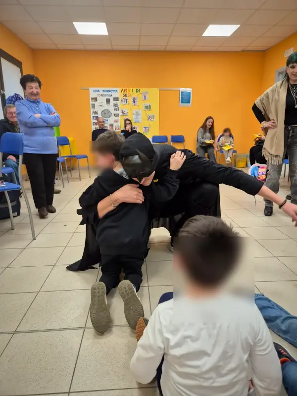 Batman e il festeggiato si abbracciano davanti agli ospiti