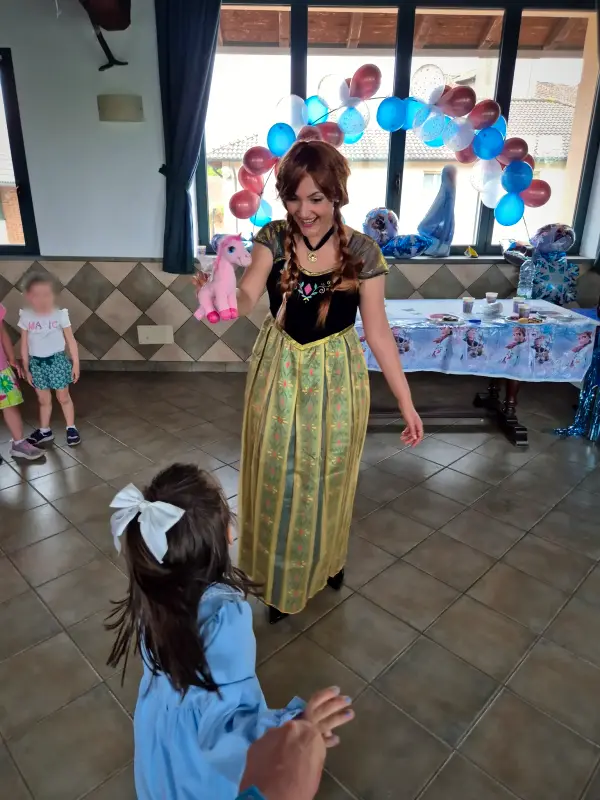 Anna balla con una bambina, sotto l'arco di palloncini