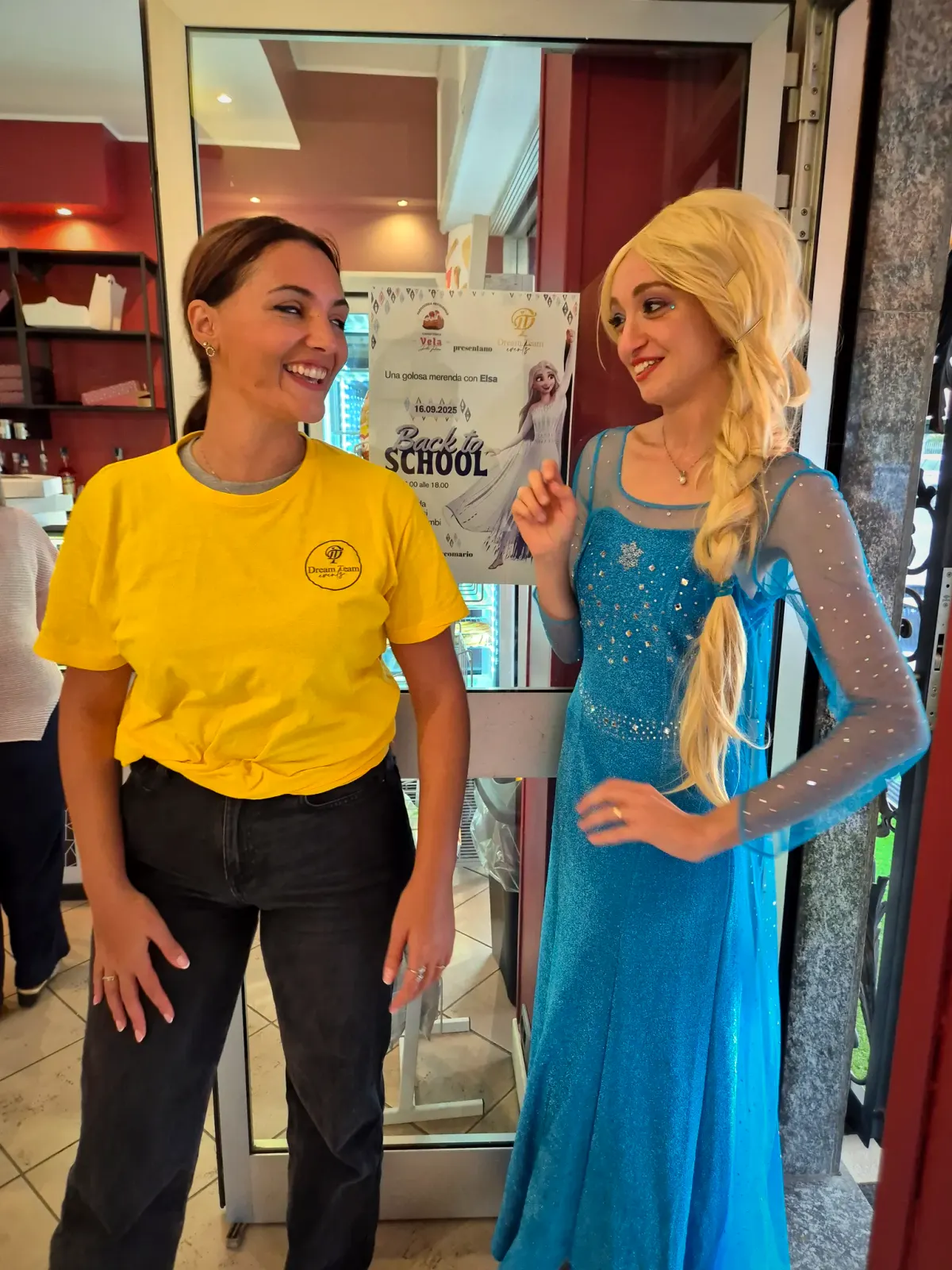 Un'animatrice della squadra ed Elsa all'ingresso di un negozio