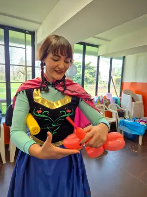 Anna modella un palloncino rosso nel salone della festa