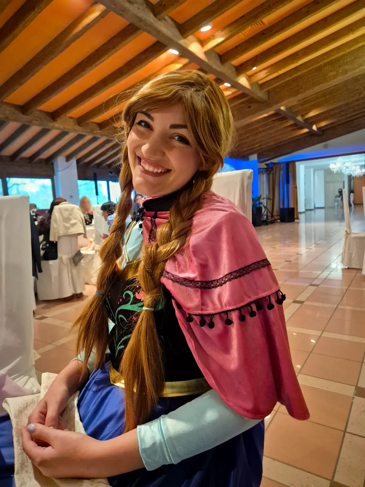 Anna nella sala della festa, sotto le travi di legno