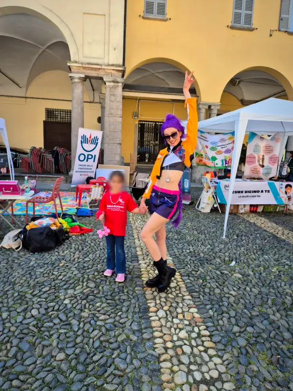 Rumi saluta una bambina in piazza, davanti agli stand della festa