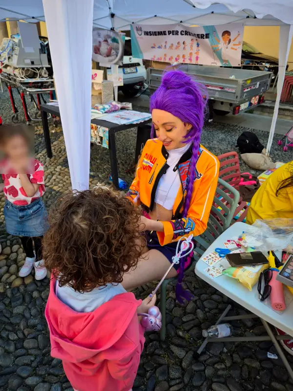 Rumi al tavolo del truccabimbi sotto il gazebo, con i bambini
