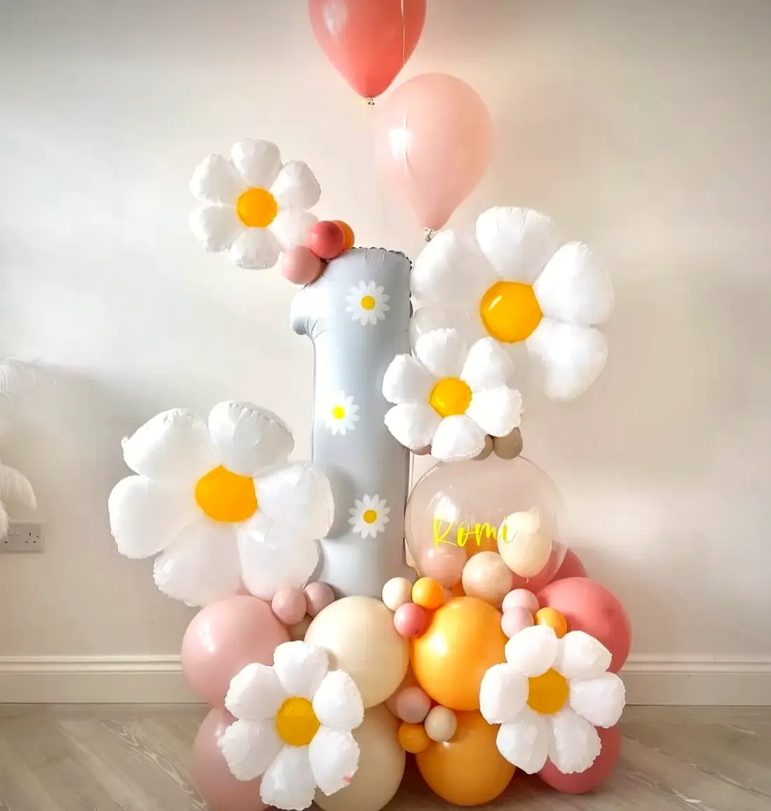 Composizione di palloncini con il numero uno e le margherite