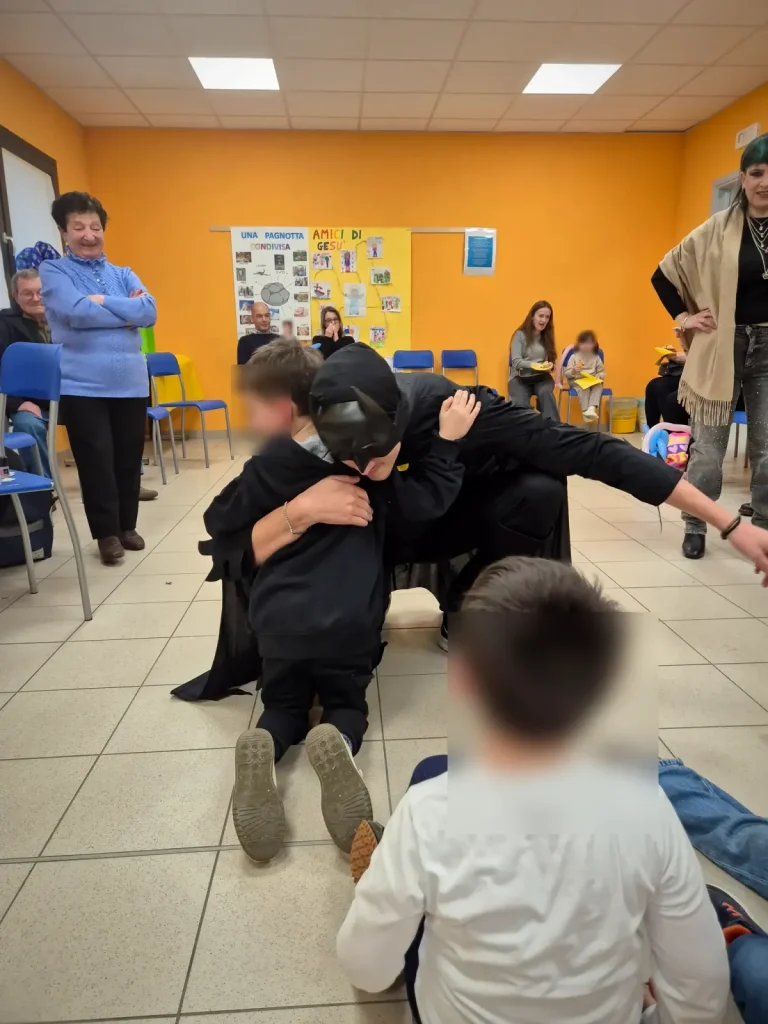 Batman e il festeggiato si abbracciano davanti agli ospiti