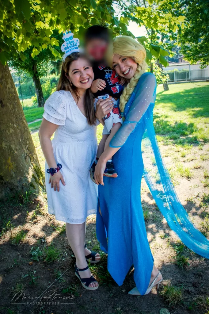 La mamma, il festeggiato ed Elsa sotto gli alberi del parco
