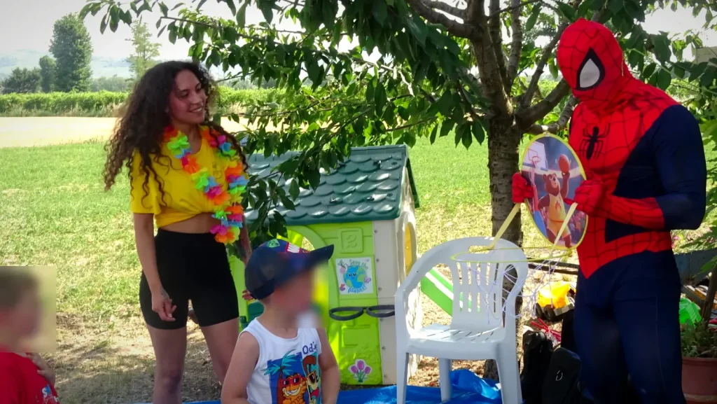 L'animatrice e Spiderman con i bambini in giardino, all'inizio della festa