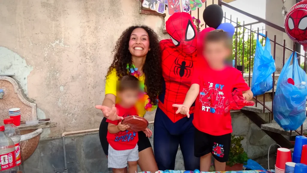 L'animatrice, Spiderman e due bambini davanti al tavolo della festa